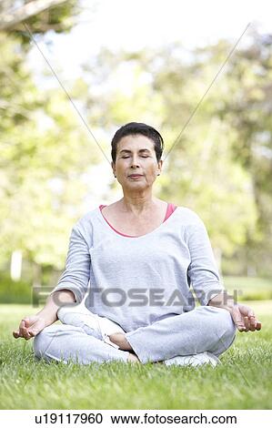 Stock Image - Senior Woman Doing Yoga In Park. Fotosearch