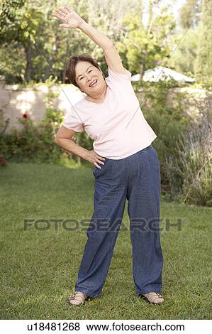 Senior Woman Exercising In Garden View Large Photo Image Stock Photo - Senior Woman Exercising In Garden. Fotosearch