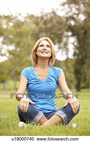 Stock Image - Senior Woman Relaxing In Park. Fotosearch