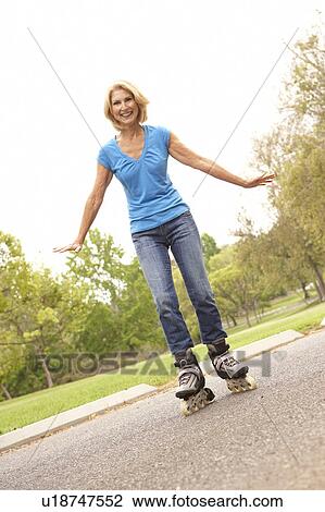 Stock Image - Senior Woman Skating In Park. Fotosearch