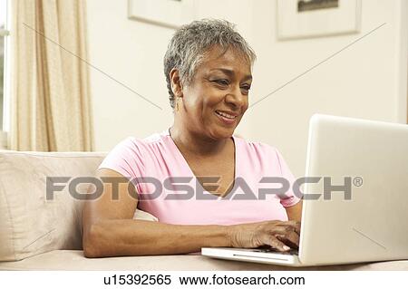 Stock Photography - Senior Woman Using Laptop At Home. Fotosearch