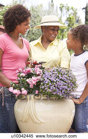 Stock Photography - Senior Woman With Adult Daughter Gardening Together. Fotosearch