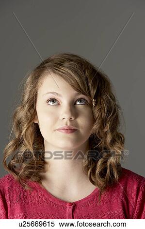 Stock Photography - Studio Portrait Of Teenage Girl Looking Up. Fotosearch