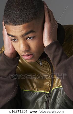 Stock Image - Teenage Boy Covering Ears With Hands. Fotosearch