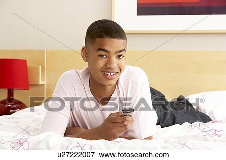 Teenage Boy In Bedroom With Mobile Phone View Large Photo Image Stock Photo - Teenage Boy In Bedroom With Mobile Phone. Fotosearch