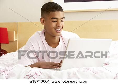 Teenage Boy Using Laptop In Bedroom View Large Photo Image Picture - Teenage Boy Using Laptop In Bedroom. Fotosearch