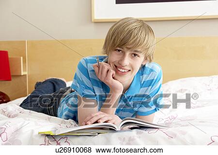 Stock Photo - Teenage Boy Writing In Diary In Bedroom. Fotosearch