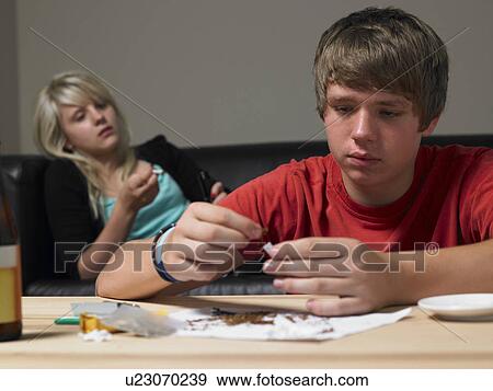 Stock Photo - Teenage Couple Taking Drugs At Home. Fotosearch