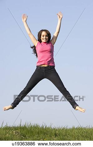 Stock Photograph - Teenage Girl Jumping In Summer Meadow. Fotosearch