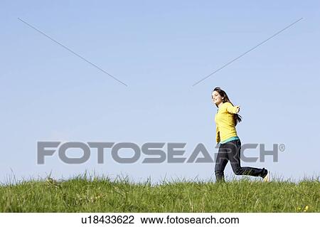 Stock Image - Teenage Girl Running Through Summer Meadow. Fotosearch