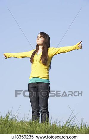 Stock Photography - Teenage Girl Standing In Summer Meadow. Fotosearch