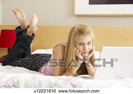 Stock Photograph - Teenage Girl Using Laptop In Bedroom. Fotosearch