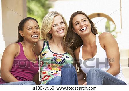 Stock Photo - Three Girlfriends Sitting On Steps Of Building. Fotosearch