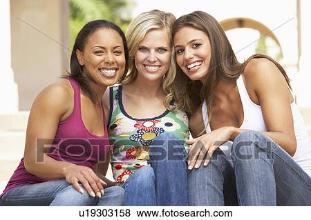 Stock Photo - Three Girlfriends Sitting On Steps Of Building. Fotosearch