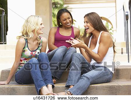 Stock Photograph - Three Girlfriends Sitting On Steps Of Building. Fotosearch
