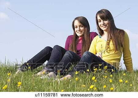 Twin Teenage Girls Sitting In Summer Meadow View Large Photo Image Stock Image - Twin Teenage Girls Sitting In Summer Meadow. Fotosearch