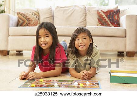 Stock Photography - Two Girls Playing Board Game At Home. Fotosearch