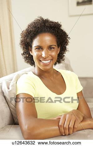 Stock Image - Woman Relaxing On Sofa At Home. Fotosearch