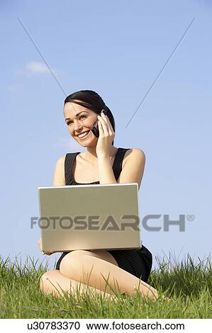 Woman Using Laptop And Mobile Phone Outdoors In Countryside View Large Photo Image Stock Image - Woman Using Laptop And Mobile Phone Outdoors In Countryside. Fotosearch