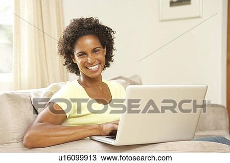 Stock Image - Woman Using Laptop At Home. Fotosearch