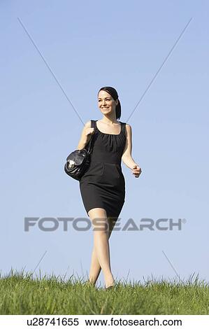 Stock Photography - Woman Walking Through Summer Countryside. Fotosearch