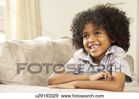 Young Boy Relaxing On Sofa At Home View Large Photo Image Stock Photo - Young Boy Relaxing On Sofa At Home. Fotosearch