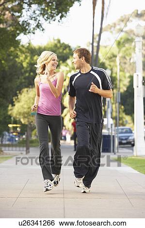 Stock Photograph - Young Couple Jogging On Street. Fotosearch