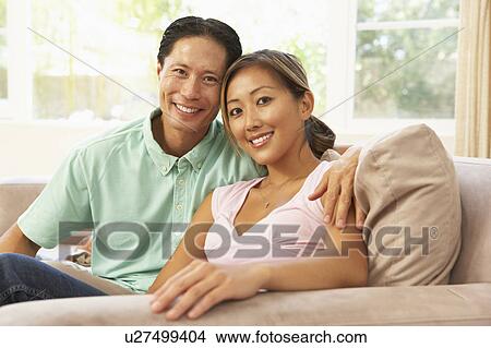 Picture - Young Couple Relaxing On Sofa At Home. Fotosearch