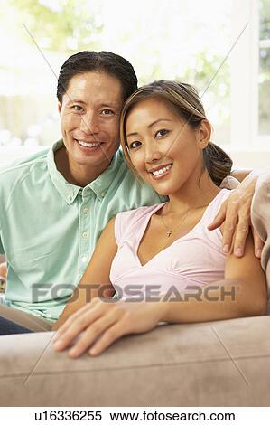 Stock Photography - Young Couple Relaxing On Sofa At Home. Fotosearch