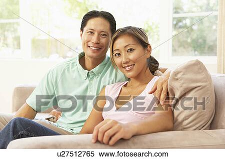 Stock Photography - Young Couple Relaxing On Sofa At Home. Fotosearch