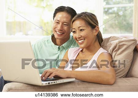 Young Couple Using Laptop At Home View Large Photo Image Stock Photograph - Young Couple Using Laptop At Home. Fotosearch