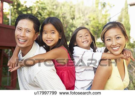 Stock Photo - Young Family Playing In Garden Together. Fotosearch