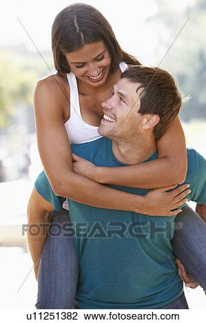 Young Man Giving Woman Piggyback Outdoors View Large Photo Image Stock Image - Young Man Giving Woman Piggyback Outdoors. Fotosearch