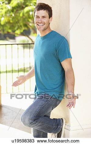 Stock Image - Young Man Leaning Against Pillar. Fotosearch