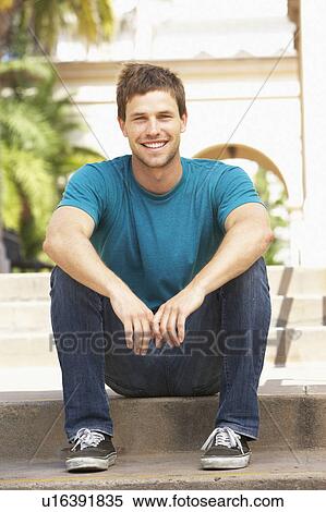 Stock Photography - Young Man Sitting On Steps Of Building. Fotosearch