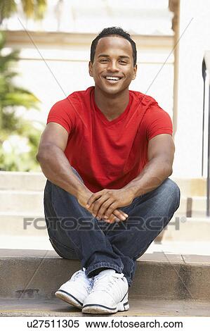 Stock Photography - Young Man Sitting On Steps Of Building. Fotosearch