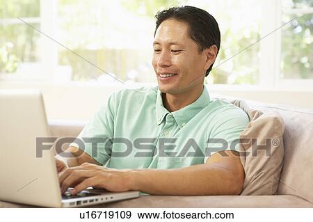 Young Man Using Laptop At Home View Large Photo Image Stock Photo - Young Man Using Laptop At Home. Fotosearch