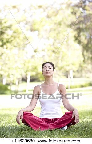 Stock Image - Young Woman Doing Yoga In Park. Fotosearch