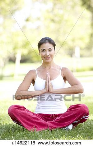 Stock Photo - Young Woman Doing Yoga In Park. Fotosearch