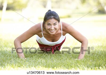 Stock Image - Young Woman Exercising In Park. Fotosearch