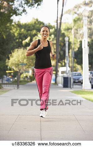 Stock Photograph - Young Woman Jogging On Street. Fotosearch