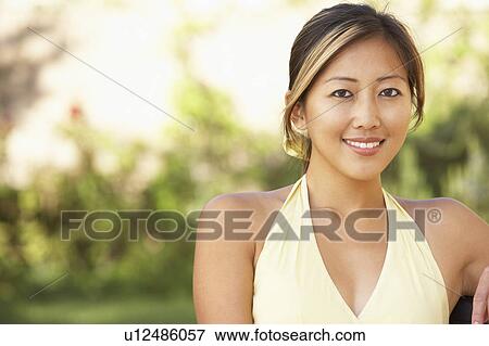 Stock Photo - Young Woman Relaxing In Garden. Fotosearch