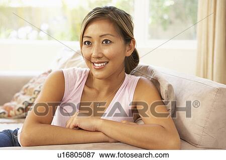 Stock Photo - Young Woman Relaxing On Sofa At Home. Fotosearch
