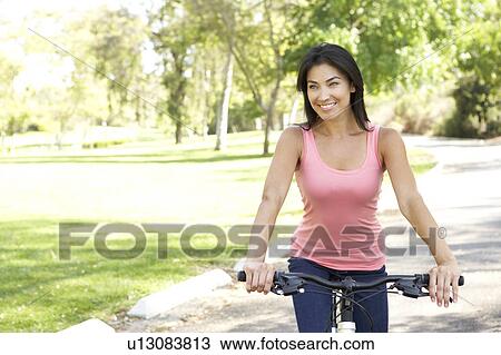 Young Woman Riding Bike In Park View Large Photo Image Stock Image - Young Woman Riding Bike In Park. Fotosearch