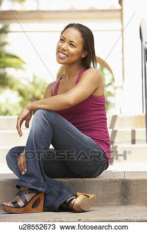 Stock Image - Young Woman Sitting On Steps Of Building. Fotosearch