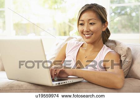 Picture - Young Woman Using Laptop At Home. Fotosearch