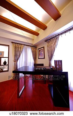 Stock Image - A modern desk in a bright, decorated room. Fotosearch