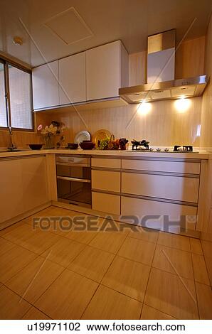 Stock Image - Bright kitchen with fruits and bowls on the counter, next to the stove. Fotosearch