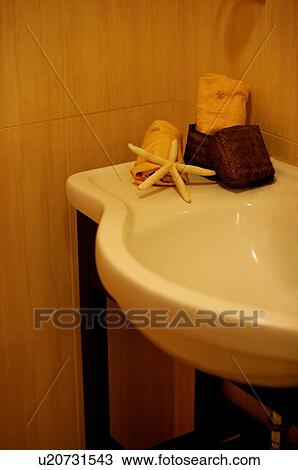 Stock Image - Corner of a basin, with hand towels and a starfish decoration on it. Fotosearch