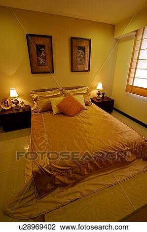 Made bed against a wall with framed artworks, with small tables on either side of the bed View Large Photo Image Stock Image - Made bed against a wall with framed artworks, with small tables on either side of the bed. Fotosearch
